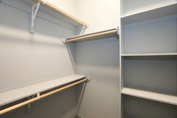 Forum Fitzsimons apartment closet with built in shelves and hanging rods.