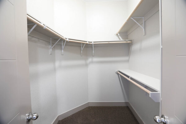 Forum Fitzsimons apartment closet with built in shelves and clothes rods.