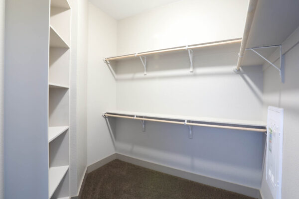 Forum Fitzsimons apartment closet with built in shelves and clothes rods.