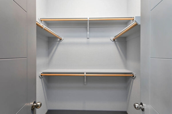 Forum Fitzsimons apartment closet with built in shelves and clothes rods.