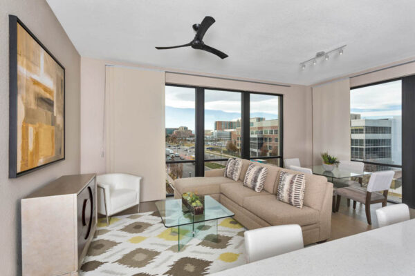 Forum Fitzsimons apartment living room with plush seating, elegant dining table, and large windows.