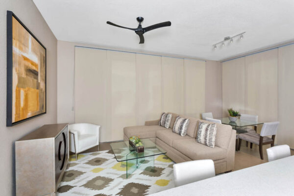 Forum Fitzsimons apartment living space with plush seating, elegant dining table, and large windows.