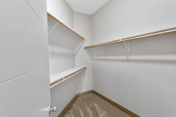 Forum Fitzsimons apartment closet with built in shelves and clothes rods.