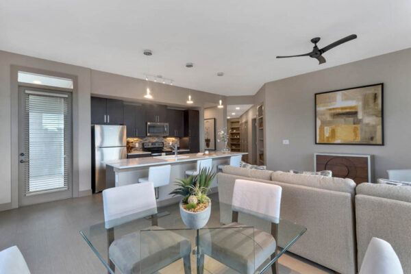 Forum Fitzsimons apartment living area with plush seating, elegant dining, and modern kitchen.