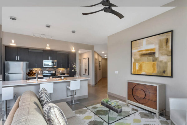 Forum Fitzsimons apartment living space with plush seating and modern kitchen.