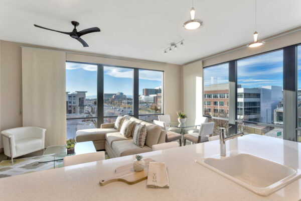 Forum Fitzsimons apartment living area with plush seating, elegant dining, and large windows.