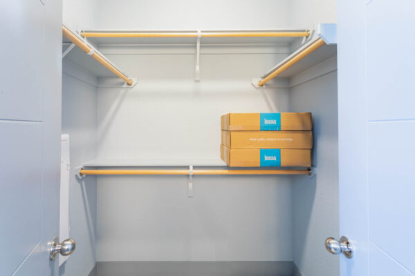 Forum Fitzsimons apartment closet with built in shelves and clothes rods.