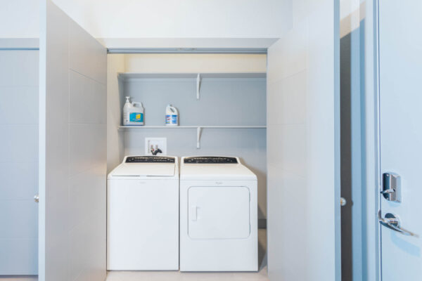 Forum Fitzsimons apartment laundry room with built in shelves, washer, and dryer.