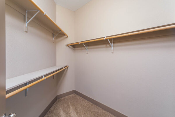 Forum Fitzsimons apartment closet with built in shelves and clothes rods.