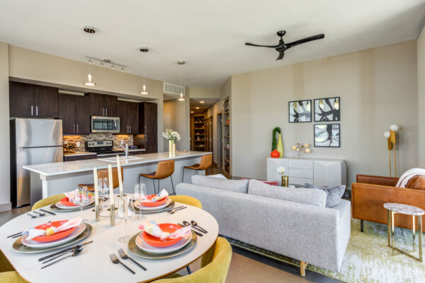 Forum Fitzsimons apartment living area with modern kitchen, plush seating, and elegant dining.