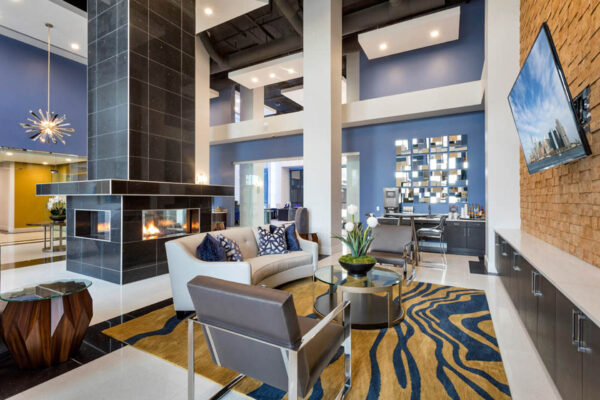 Forum Fitzsimons apartment lounge with plush seating, TV, and fireplace.