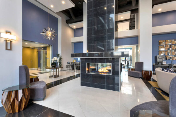 Forum Fitzsimons apartment lobby with fireplace and plush seating.