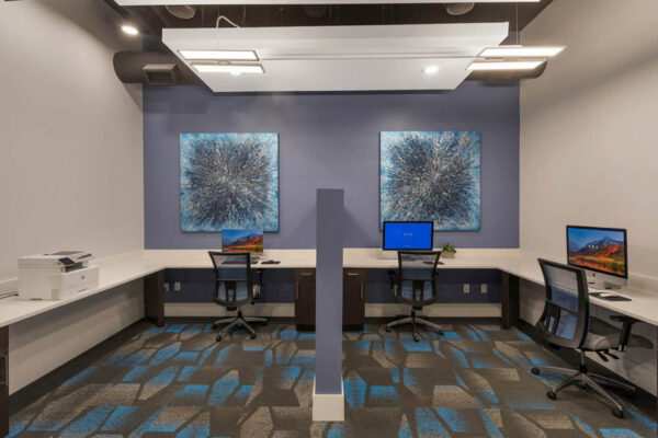 Forum Fitzsimons apartment business center with with computer desks and printer.