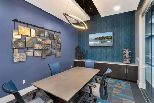 Forum Fitzsimons apartments business center with conference table and TV.