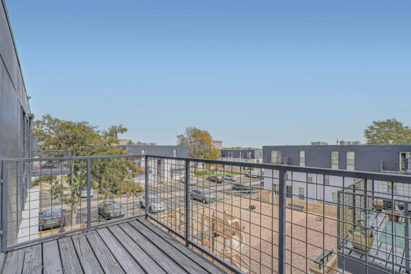 Heights on Huron apartments balcony with metal fencing and wood floors.
