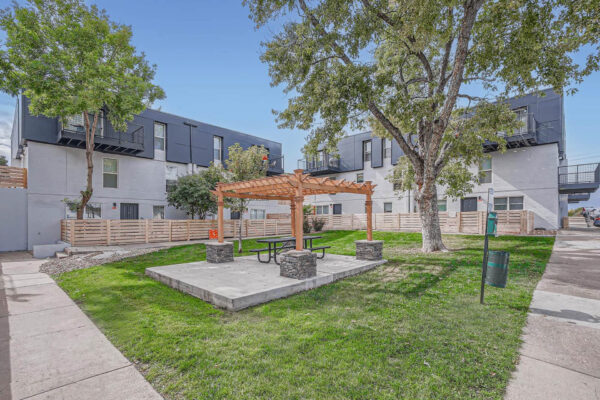 Heights on Huron apartments picnic area with pergola and large trees.