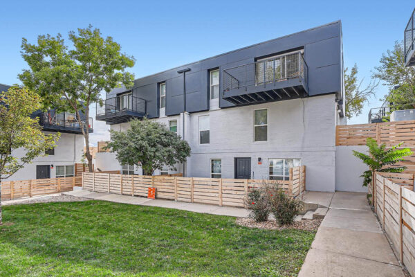 Heights on Huron apartments building with balconies, fenced entryways and grassy areas.