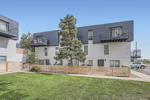 Heights on Huron apartments building with balconies, fenced entryways and grassy areas.