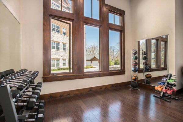 Highlands Lodge apartments fitness center with weight equipment and large sunny windows.