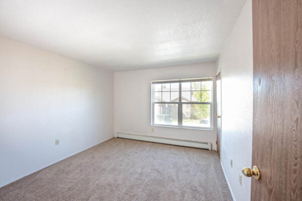 Mountain Village apartments bedroom area with large windows.