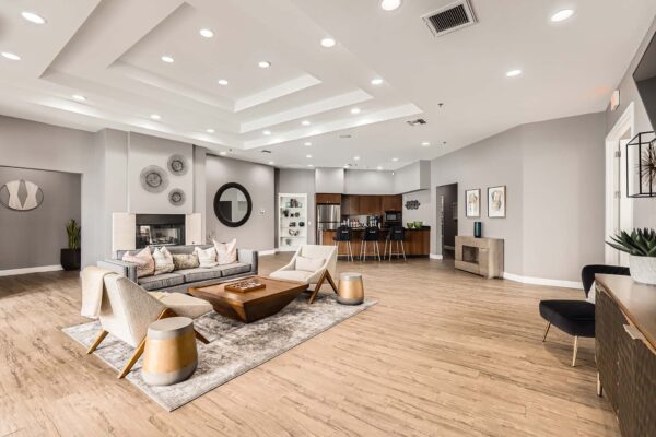 Pavilions at Arrowhead apartments community lounge with plush seating, community kitchen, and fireplace.