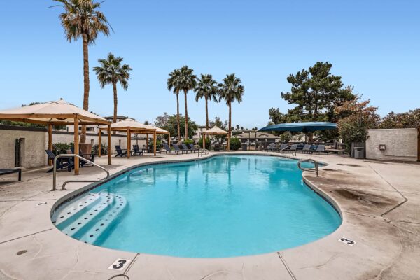 Pavilions at Arrowhead apartments pool area with lounge chairs and gazebos.