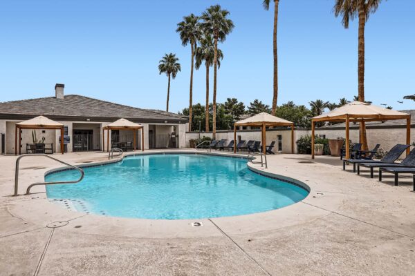 Pavilions at Arrowhead apartments pool area with lounge chairs and gazebos.
