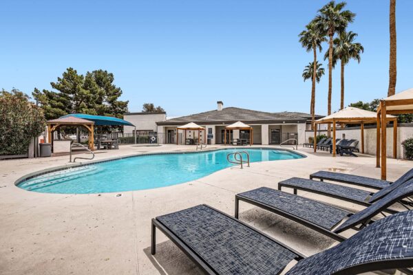 Pavilions at Arrowhead apartments pool area with lounge chairs and gazebos.