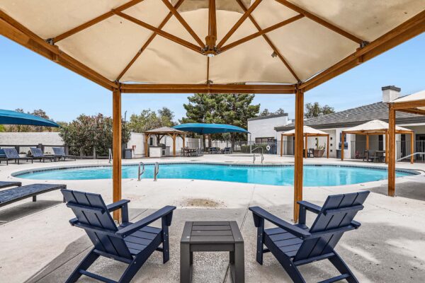 Pavilions at Arrowhead apartments pool area with lounge chairs and gazebos.