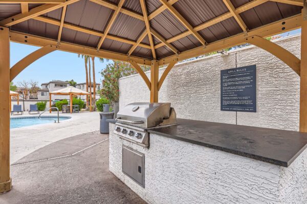 Pavilions at Arrowhead apartments pool area with BBQ grills.