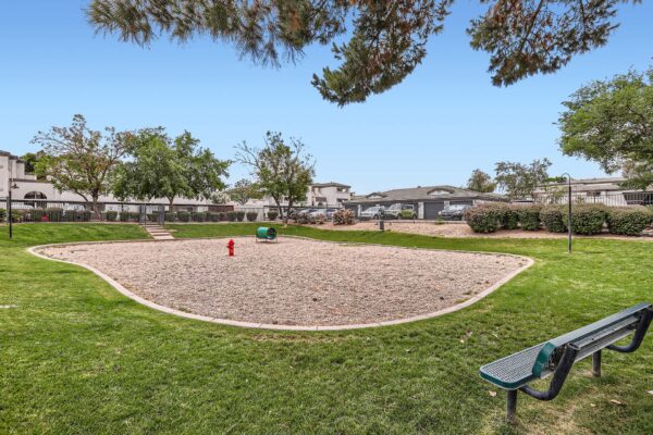 Pavilions at Arrowhead apartments dog park with agility toys and gravel play area.