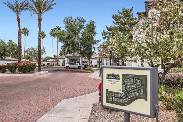 Pavilions at Arrowhead apartments driveway with stone pavers and rocky landscaping.