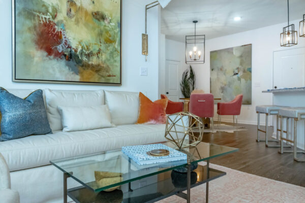 Residence at Old Hickory Lake apartments living area and dining area with wood style flooring, light fixtures, abstract artwork and comfortable seating.