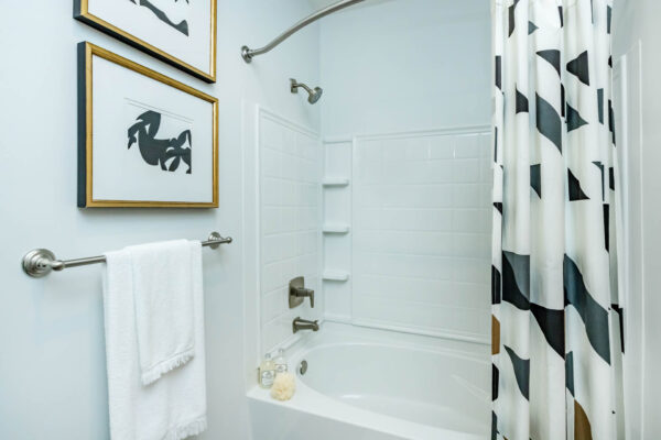 Residence at Old Hickory Lake apartments tiled shower tub and abstract artwork.