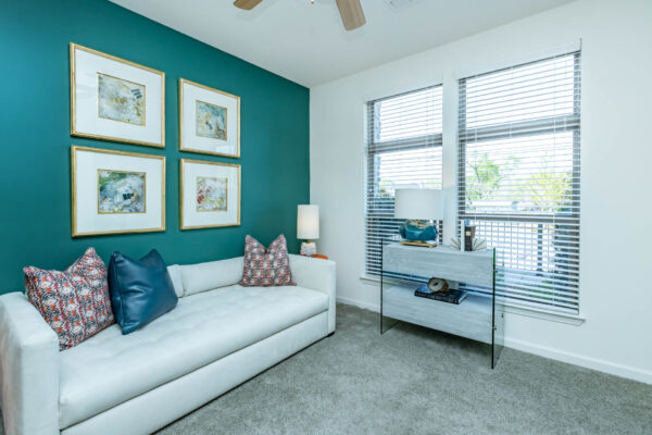 Residence at Old Hickory Lake apartments green painted walls, abstract artwork, and comfortable seating on plush carpet and carpet plush.