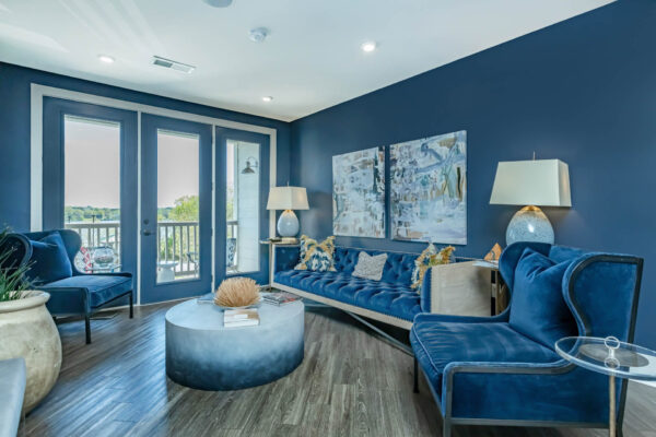 Residence at Old Hickory Lake apartments lounge seating, comfortable seating, abstract artwork, decorations on marble table, light fixtures, and large glass doors.