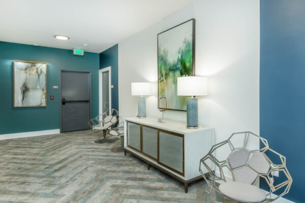 Residence at Old Hickory Lake apartments hallway with seating, abstract artwork, wooden cabinet and lighting fixtures.