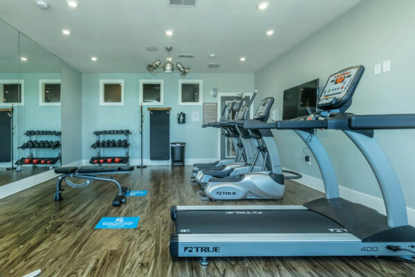 Residence at Old Hickory Lake apartments fitness center equipped with treadmills and mirrors with wood flooring.