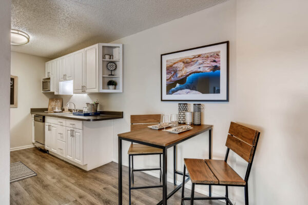 Sky at Bear Creek apartments kitchen with wood-style flooring, white cabinets, and stainless steel appliances