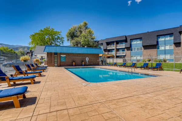 Sky at Bear Creek apartments pool lounge area with outdoor lounge chairs