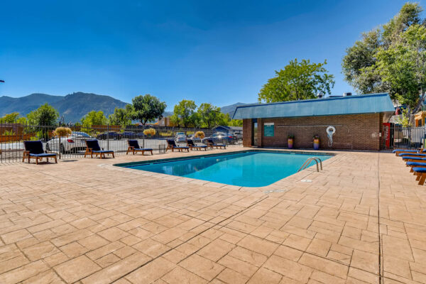 Sky at Bear Creek apartments pool lounge area with outdoor lounge chairs