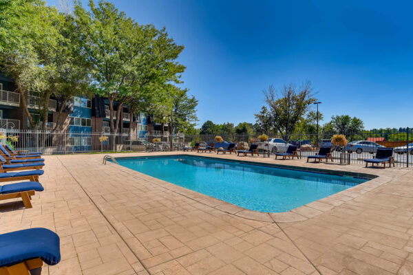 Sky at Bear Creek apartments pool lounge with lounge chairs next to parking lot