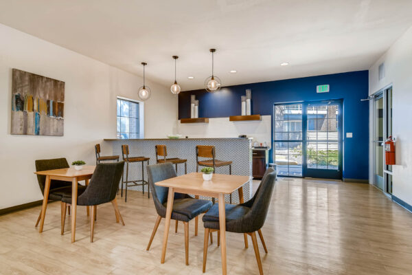 Sky at Bear Creek apartments community kitchen and lounge with tables and chairs, barstools, and coffee bar