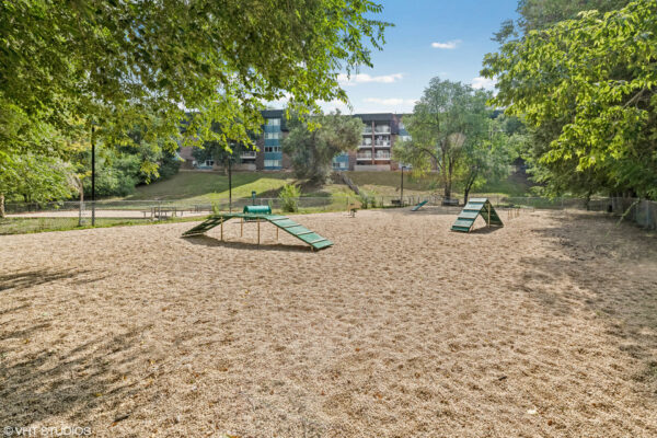 Sky at Bear Creek apartments bark park with bench and agility equipment