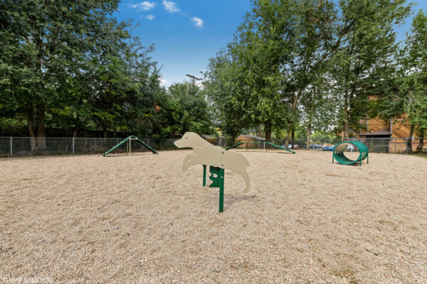 Sky at Bear Creek apartments bark park with bench and agility equipment