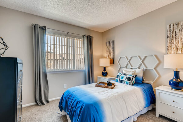 Sunset Peak apartments bedroom interior featuring gray walls and a window