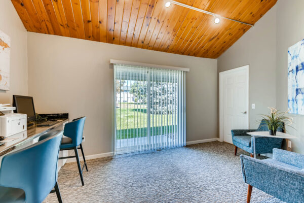 Sunset Peak apartments indoor community space with lounge area and two work spaces with computers