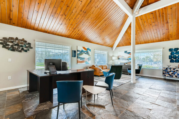 Sunset Peak apartments community space with gray tile flooring, lounge seating, and leasing desk