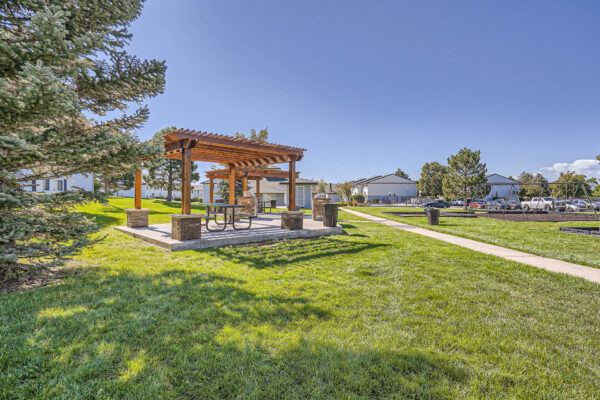 Sunset Peak apartments outdoor grassy space with wood pergola and swing set