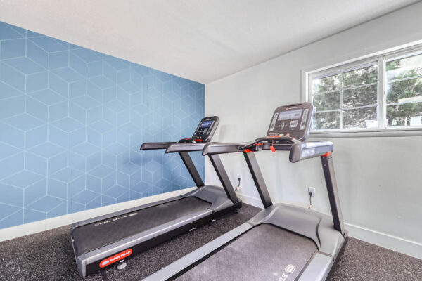 Sunset Peak apartments indoor fitness center featuring two treadmills